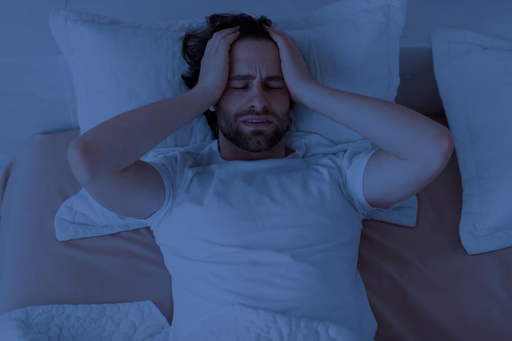 man laying down grabbing head