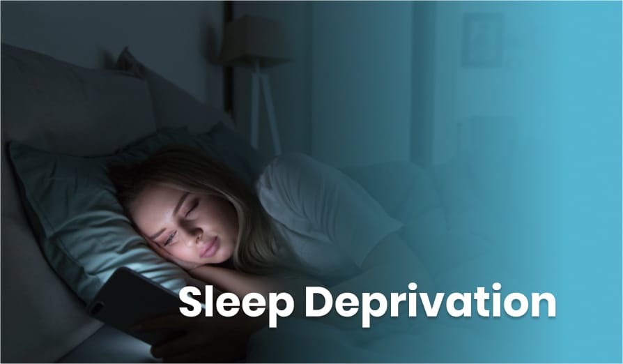 Woman using her phone in bed at night, with the words “Sleep Deprivation” overlayed on the image