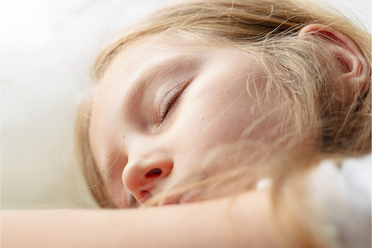 A close-up of a young child sleeping peacefully with eyes closed