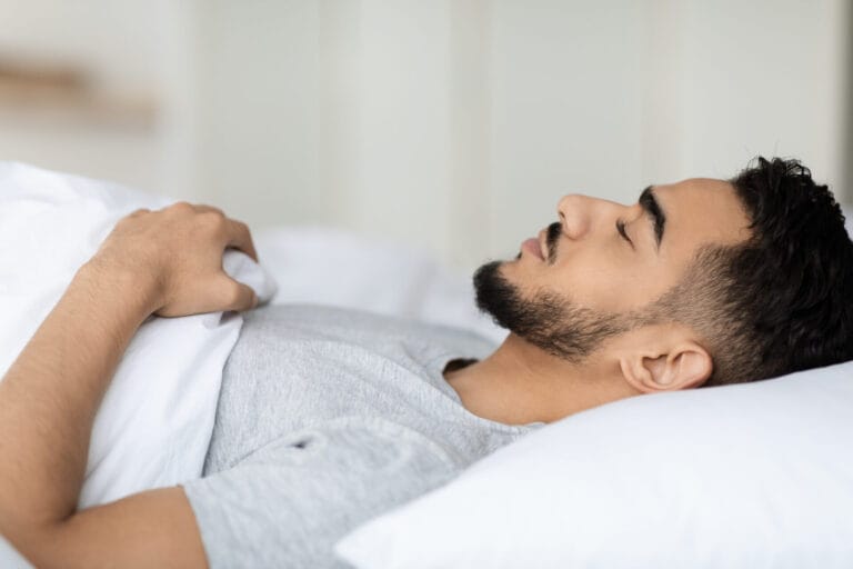 Deep Sleep. Closeup Shot Of Young Arab Man Sleeping In Bed At Home. Side View Of Millennial Middle Eastern Male Lying With Closed Eyes On Soft Pillow, Relaxed Guy Napping In Bedroom, Free Space